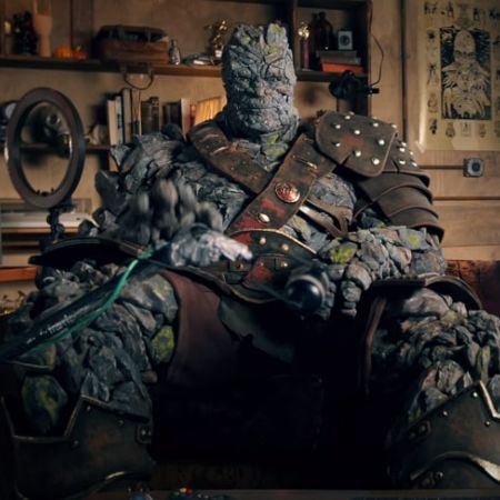 Korg is sitting on a sofa of a living room.